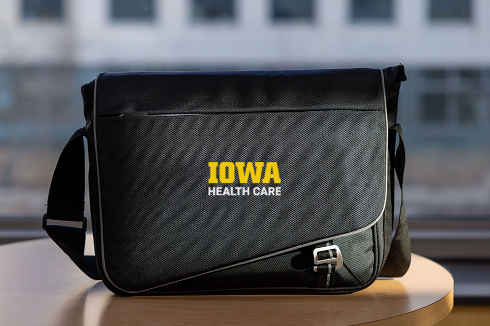 Unit lockups displayed on a laptop bag set against a blurred backdrop.